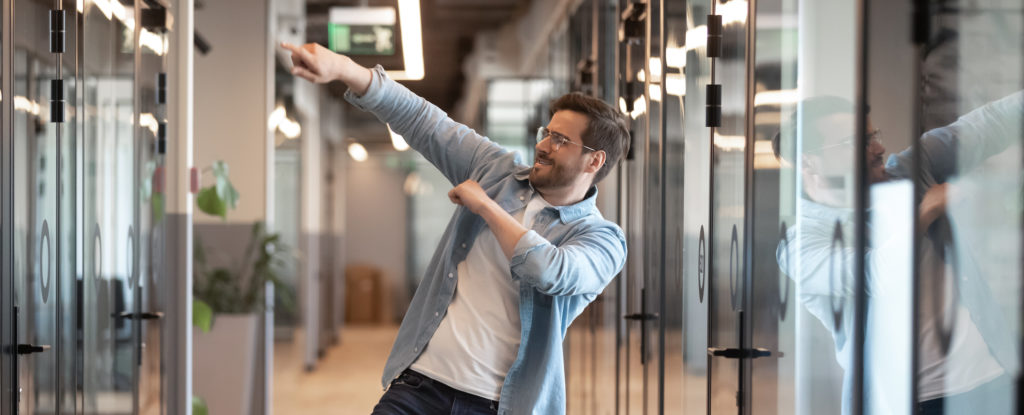 a happy male employee in an office dances